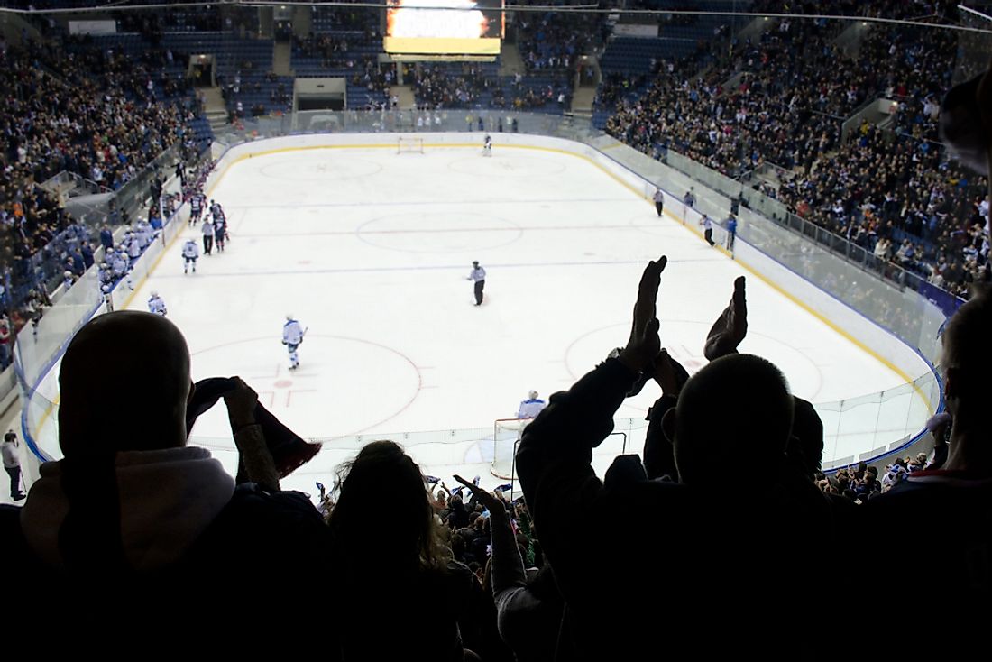 Fans cheer on in a large hockey arena. 