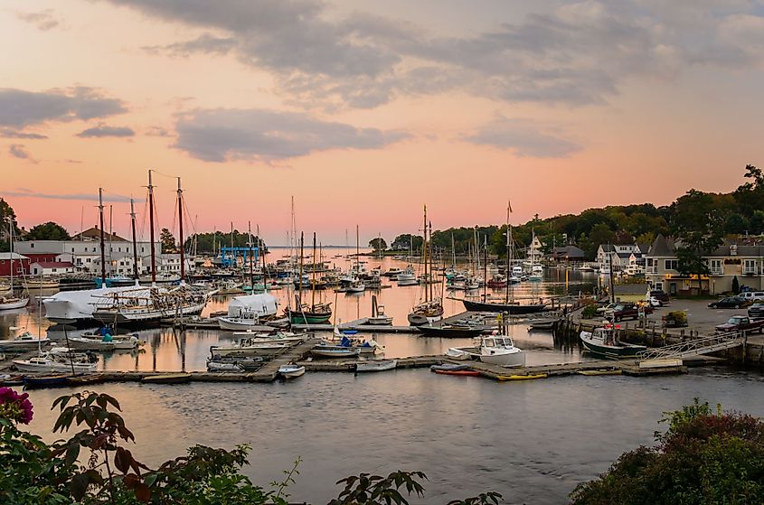 Beautiful Harbor with yachts and fishing boats moored to wooden piers at twilight in Camden, Maine. 