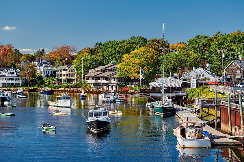 Colorful view of fall foliage and boats docked in Perkins Cove in Ogunquit, Maine.