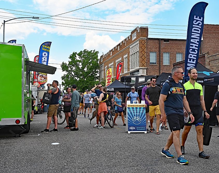EMPORIA, KANSAS USA: Some of the 4000 bike racers that are competing in tomorrow's Unbound Gravel dirt bike races stroll along the vendors' booths set up along the streets of downtown. Editorial Credit: mark reinstein via Shutterstock.