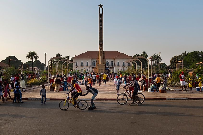 Street scene with people at the Praca dos Herois Nacionais in Guinea-Bissau, West Africa. Image used under license from Shutterstock.com.