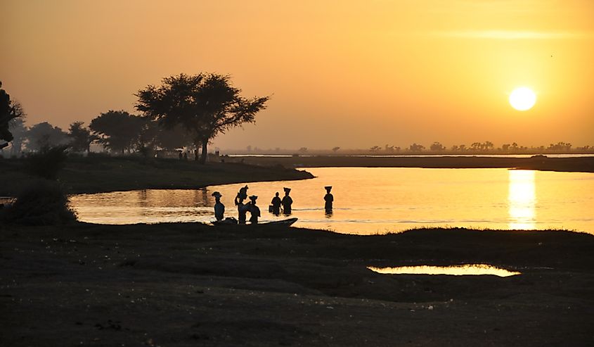 People wading into the Niger River.