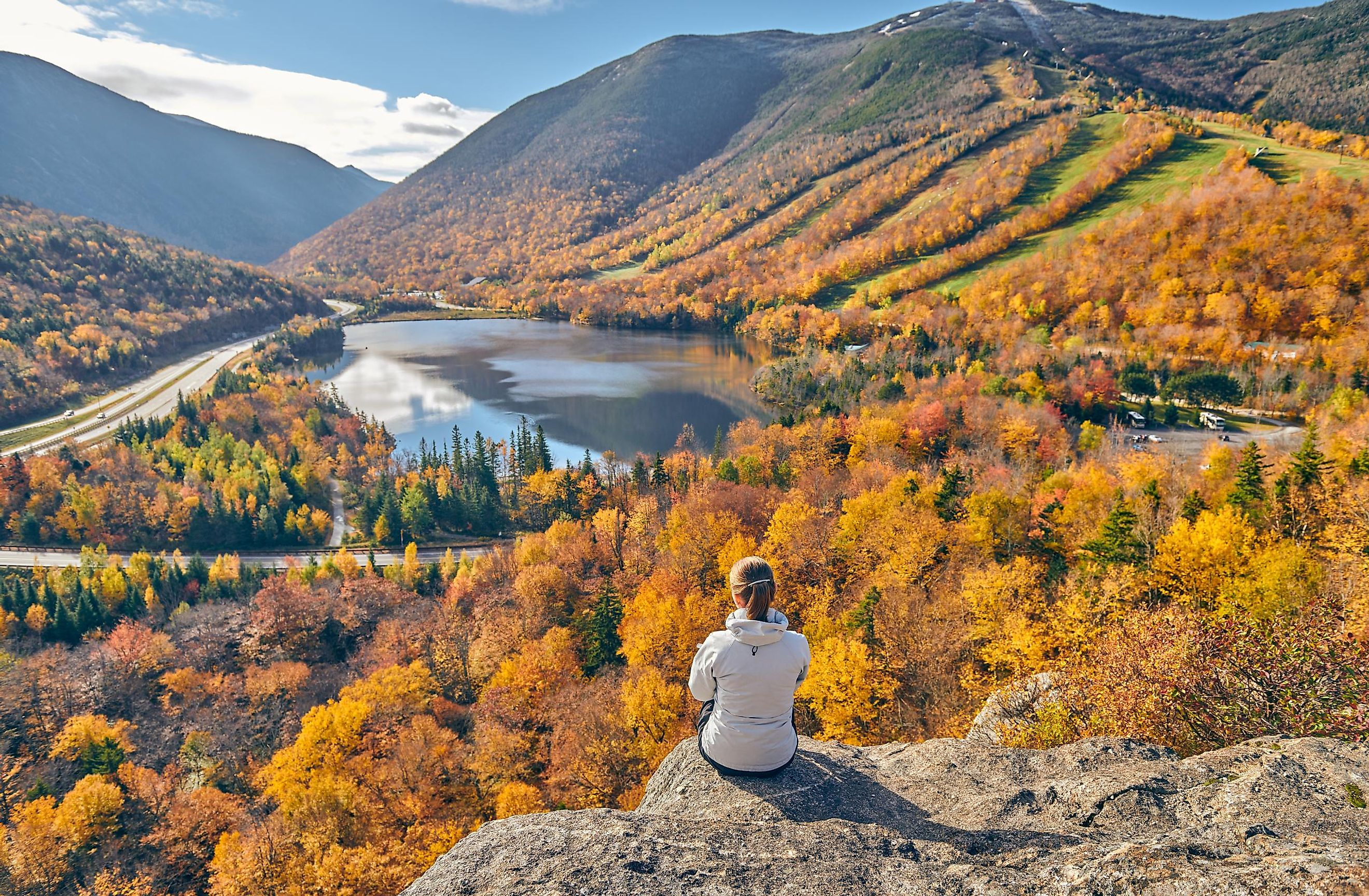 Woman hiking at Artist's Bluff near Echo Lake, Franconia Notch State Park in New Hampshire, USA during the fall.